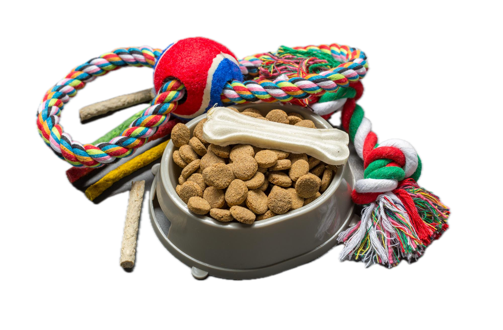 A bowl of dog food surrounded by treats and dog toys
