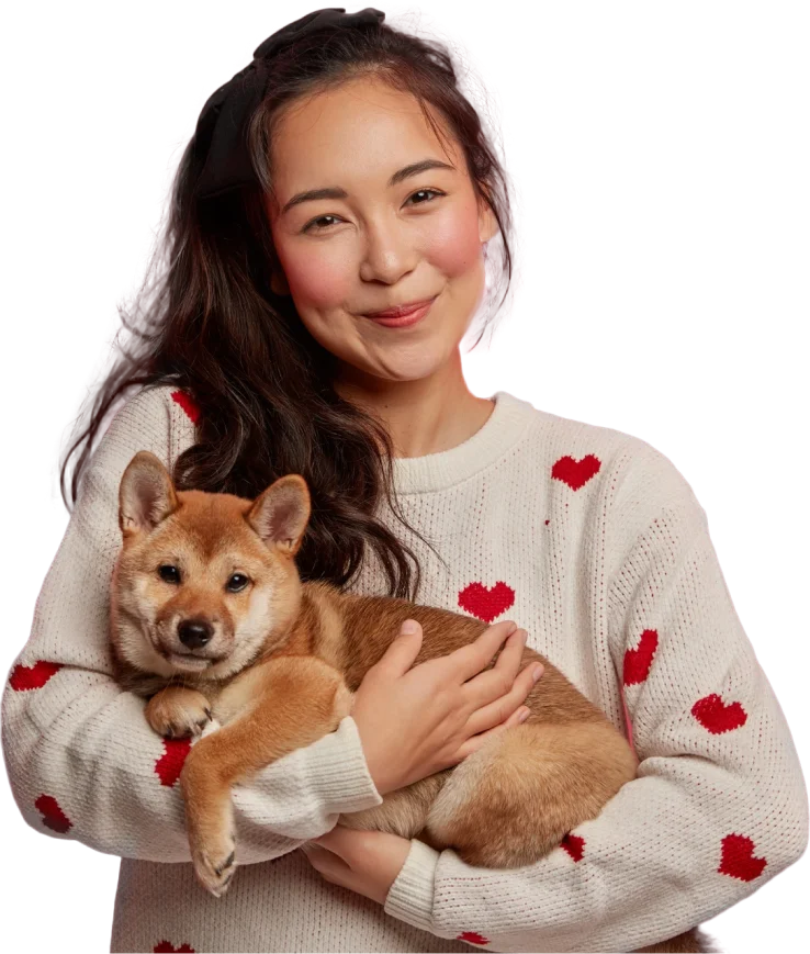 A woman smiles while holding a dog